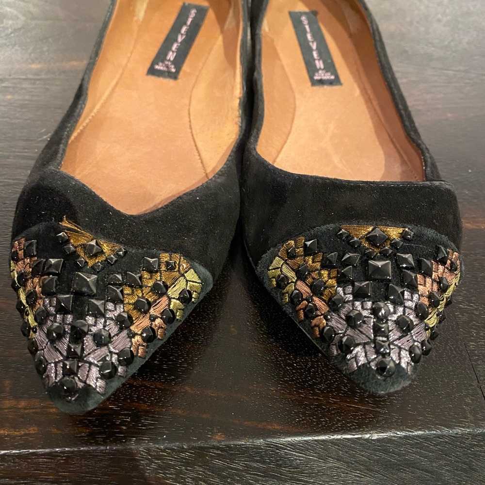 Black flats with toe embellishments.